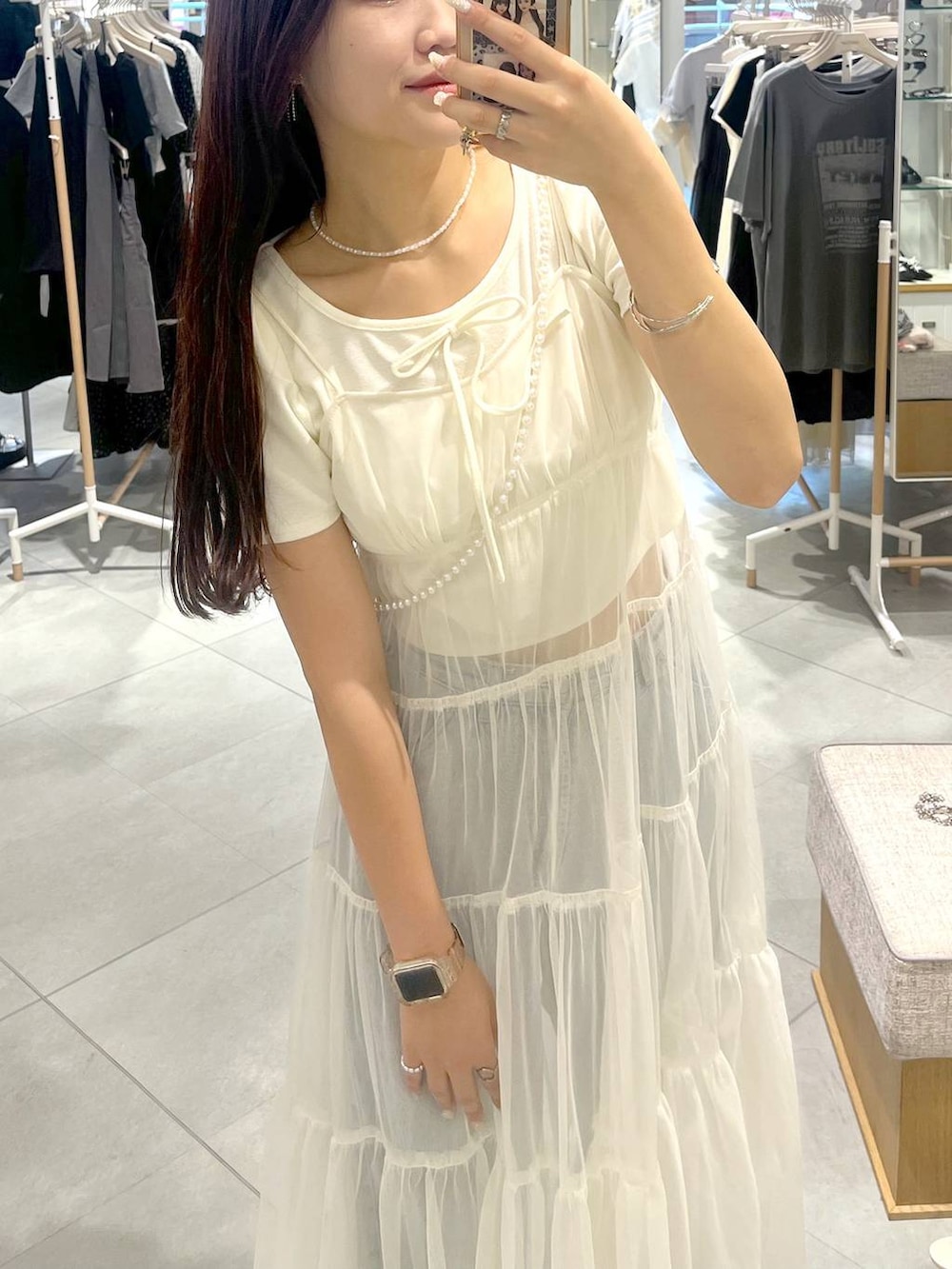 ホワイト系のワンピース、ホワイト系のキャミソール、ブルー系のデニムパンツを着用したレディースの夏コーディネートの6枚目の写真