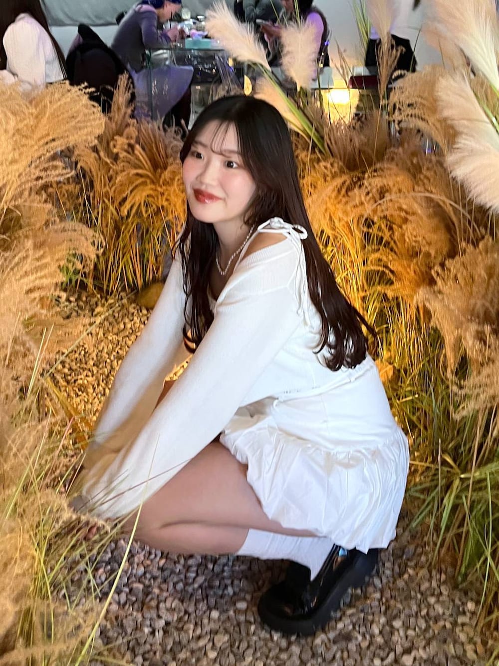 ホワイト系のスカート、ホワイト系のカーディガン/ボレロを着用したレディースの冬コーディネートの2枚目の写真