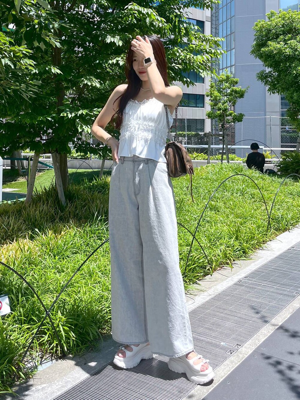 ホワイト系のキャミソール、グレー系のデニムパンツ、ホワイト系のサンダルを着用したレディースの夏コーディネートの2枚目の写真