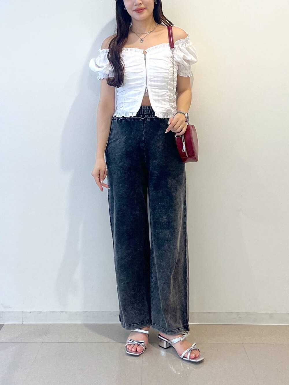 シルバー系のサンダル、レッド系のショルダーバッグ、ホワイト系のキャミソールを着用したレディースの夏コーディネートの4枚目の写真