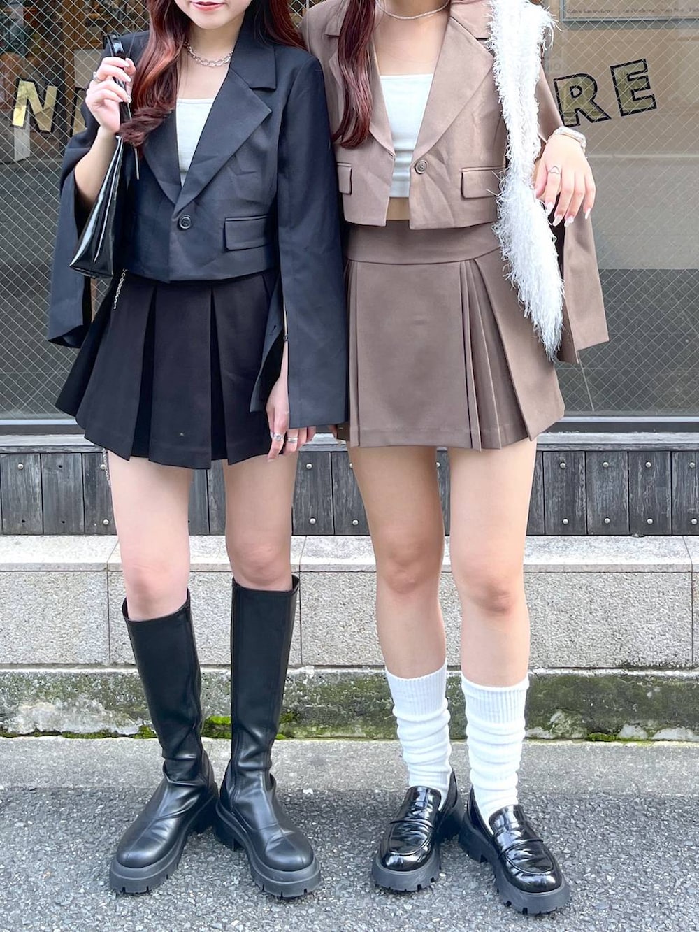 ブラック系のテーラードジャケット、ブラウン系のテーラードジャケット、ブラウン系のスカートを着用したレディースの冬コーディネートの5枚目の写真