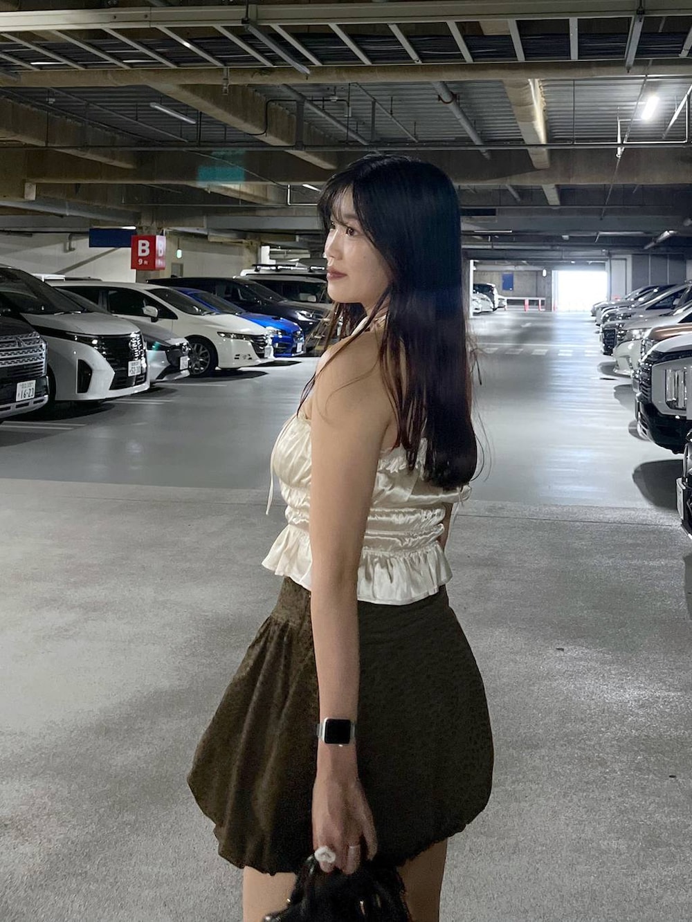 ブラック系のブーツ、ホワイト系のキャミソール、ブラウン系のスカートを着用したレディースの夏コーディネートの3枚目の写真