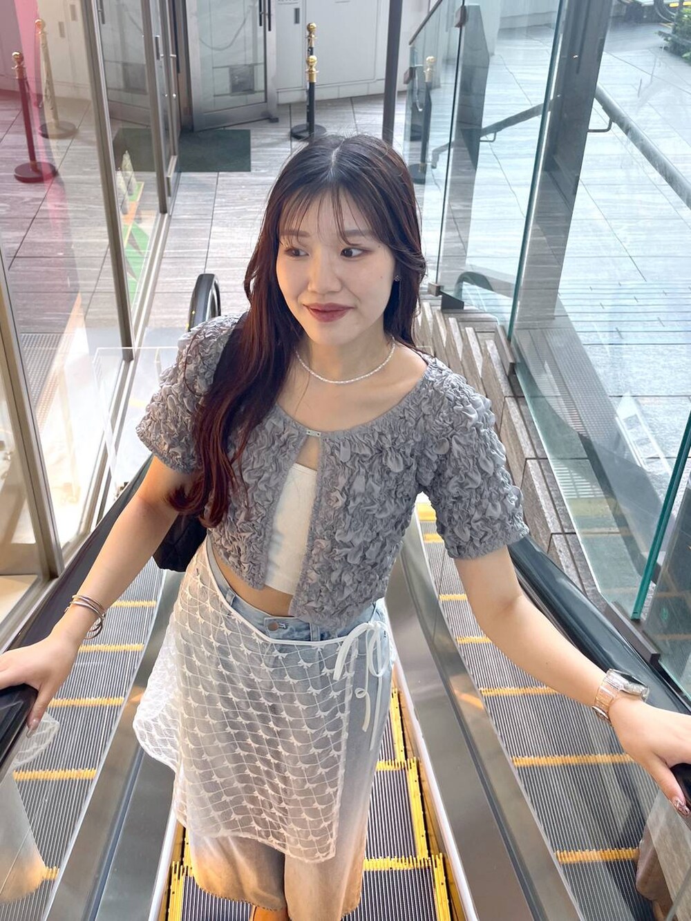 シルバー系のサンダル、ホワイト系のキャミソール、ブルー系のデニムパンツを着用したレディースの夏コーディネートの3枚目の写真