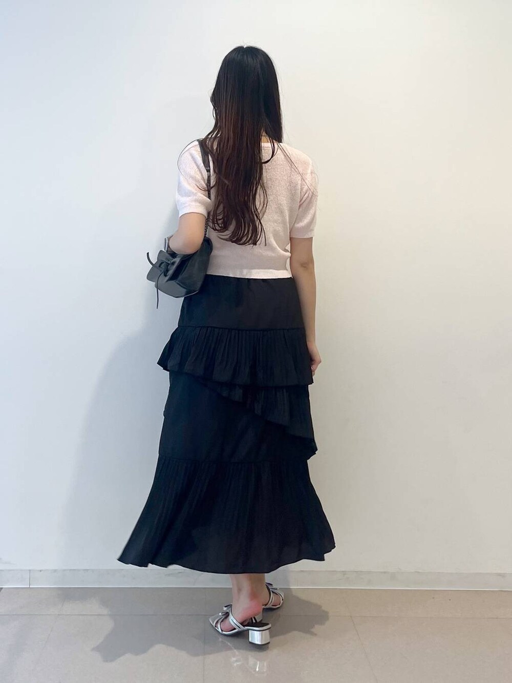 グレー系のショルダーバッグ、ホワイト系のキャミソール、ブラック系のスカートを着用したレディースの春コーディネートの4枚目の写真