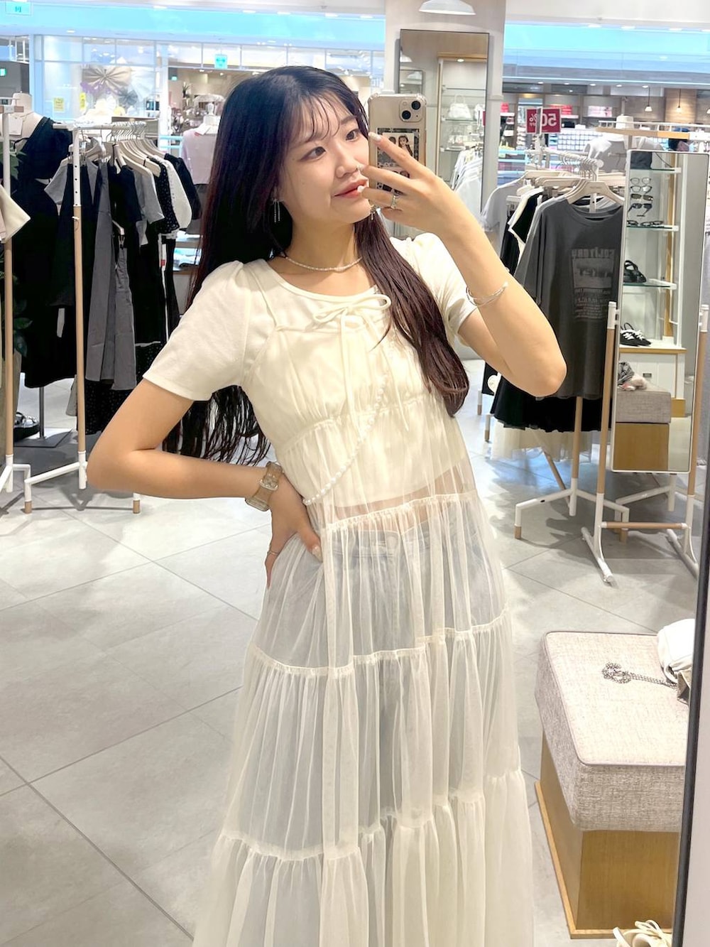 ホワイト系のワンピース、ホワイト系のキャミソール、ブルー系のデニムパンツを着用したレディースの夏コーディネートの5枚目の写真