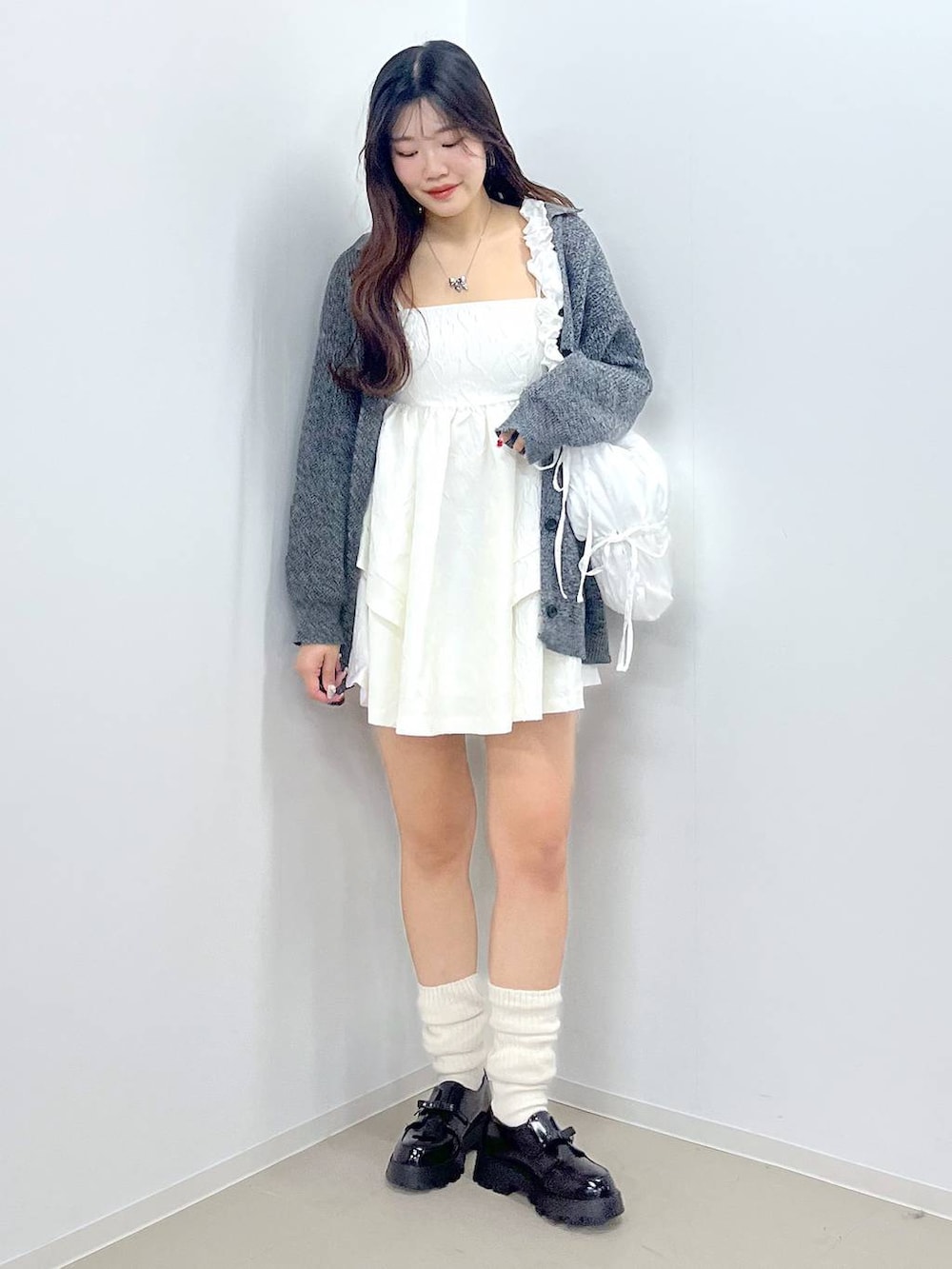 ブラック系のドレスシューズ、ホワイト系のワンピース、ホワイト系のショルダーバッグを着用したレディースの春コーディネートの5枚目の写真