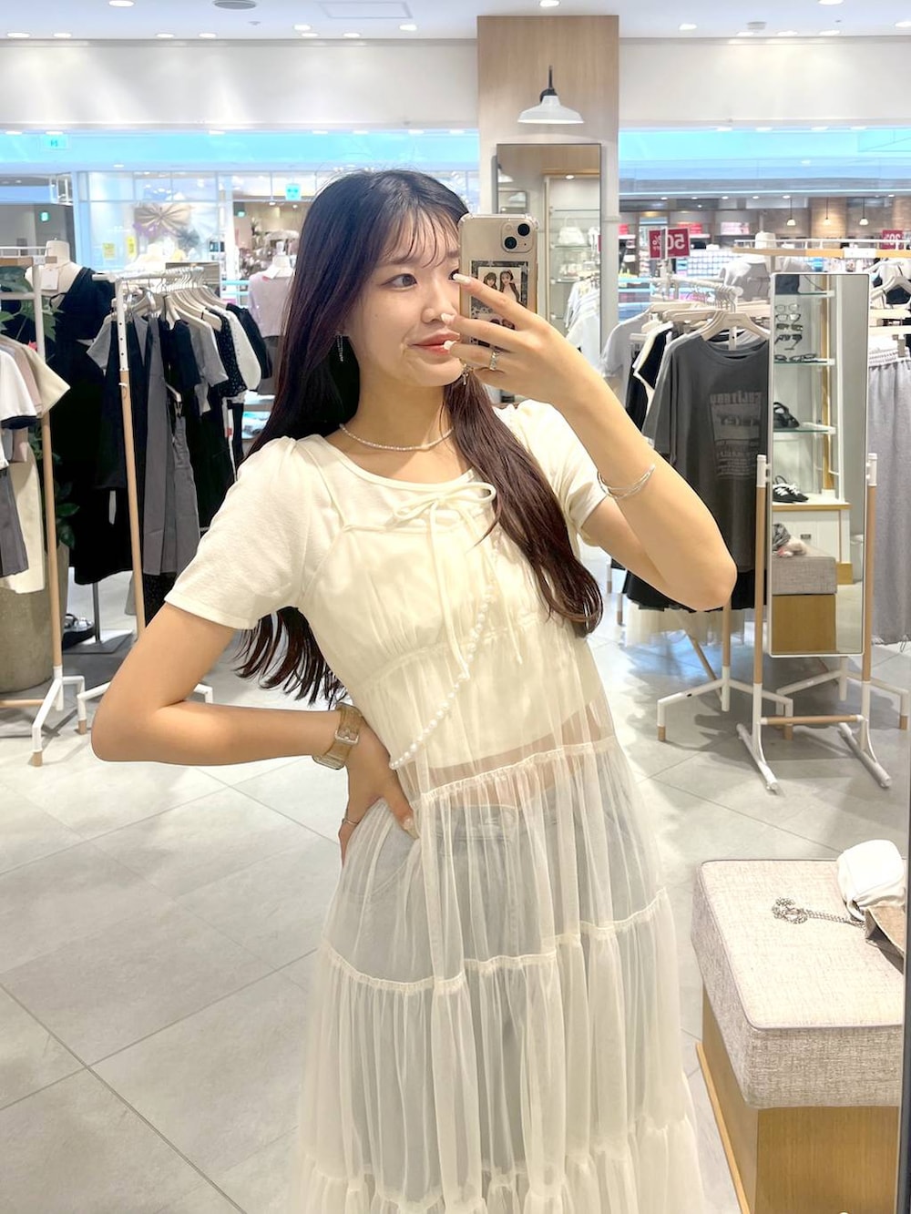 ホワイト系のワンピース、ホワイト系のキャミソール、ブルー系のデニムパンツを着用したレディースの夏コーディネートの3枚目の写真