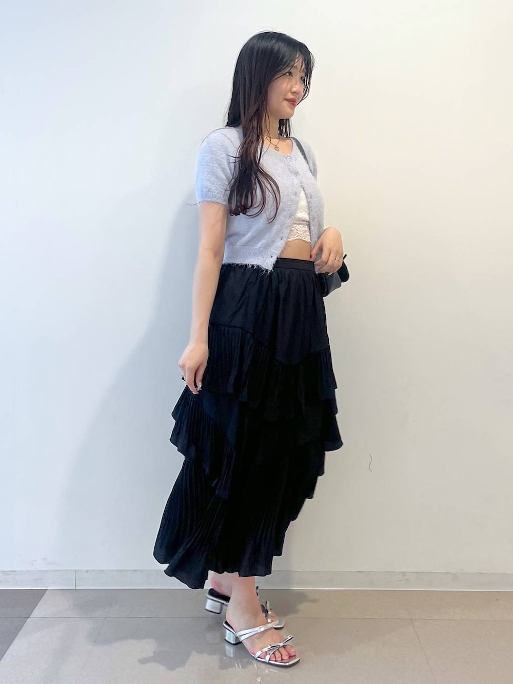 グレー系のショルダーバッグ、ブラック系のスカート、ホワイト系のキャミソールを着用したレディースの春コーディネートの5枚目の写真