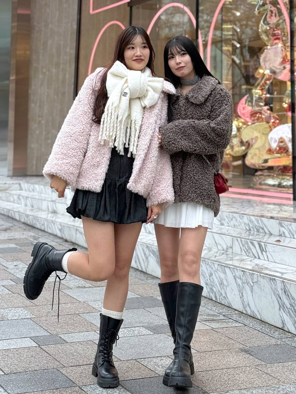 レッド系のショルダーバッグ、ブラック系のブーツ、ピンク系のステンカラーコートを着用したレディースの秋コーディネートの4枚目の写真