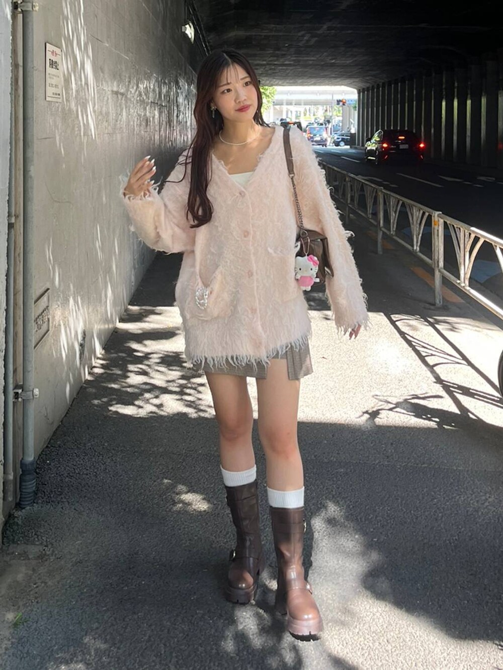 ブラウン系のショルダーバッグ、ブラウン系のブーツ、ホワイト系のキャミソールを着用したレディースの秋コーディネートの2枚目の写真