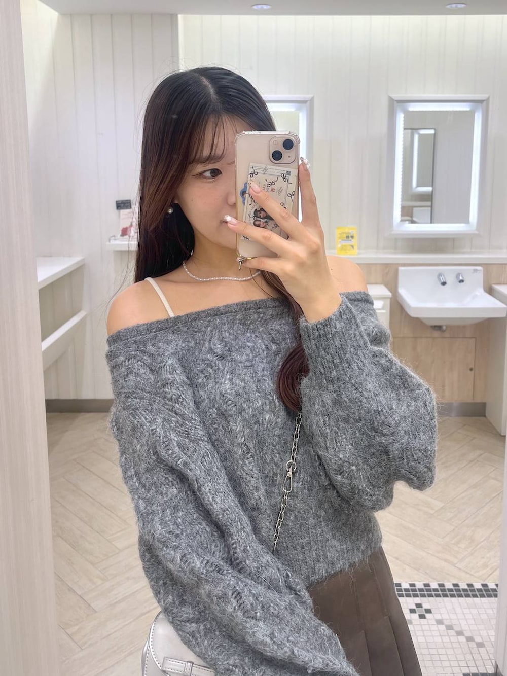 ブラウン系のスカート、ホワイト系のキャミソール、シルバー系のショルダーバッグを着用したレディースの秋コーディネートの3枚目の写真