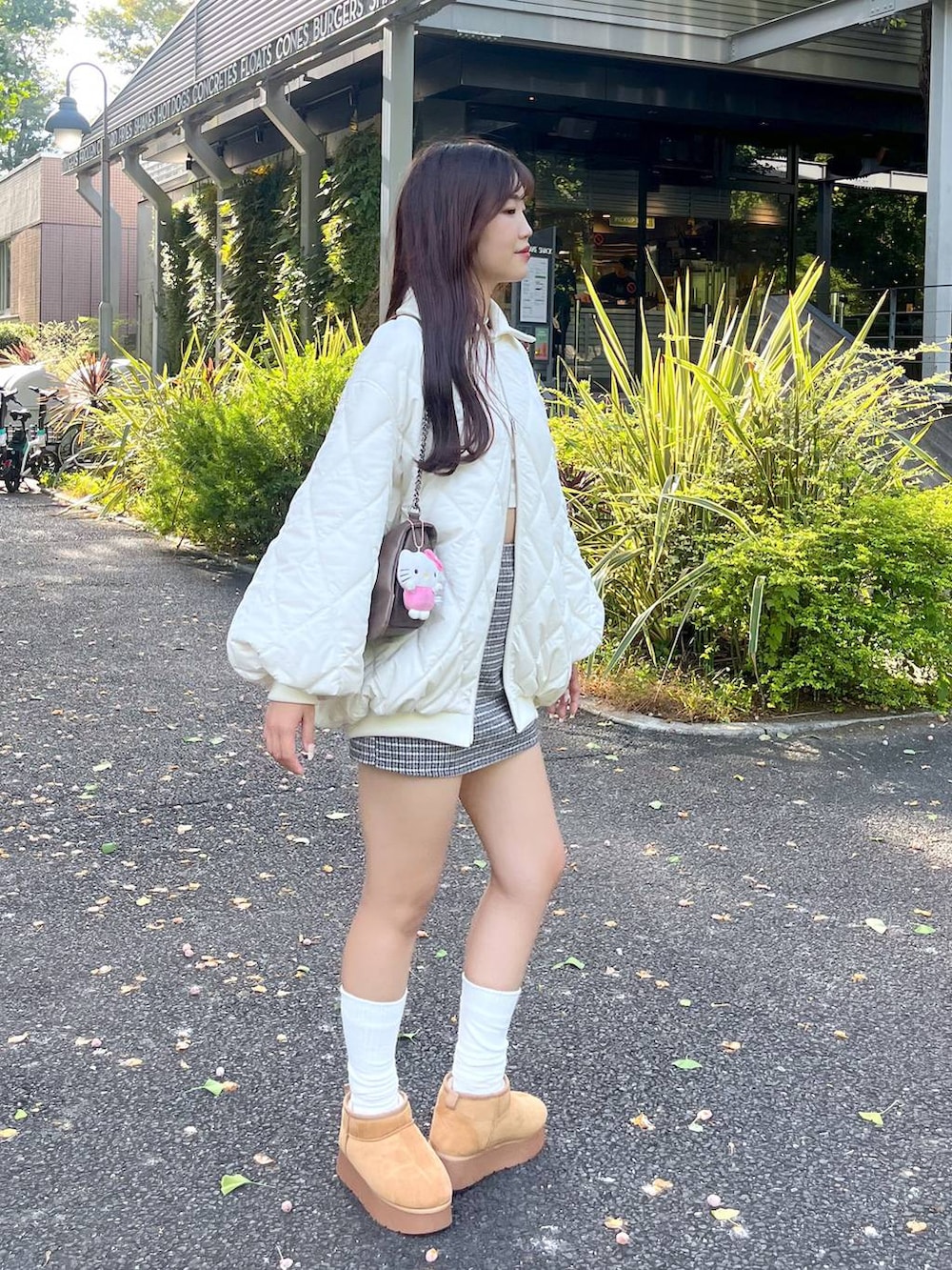 ブラウン系のショルダーバッグ、ホワイト系のTシャツ/カットソー、ベージュ系のブーツを着用したレディースの秋コーディネートの6枚目の写真