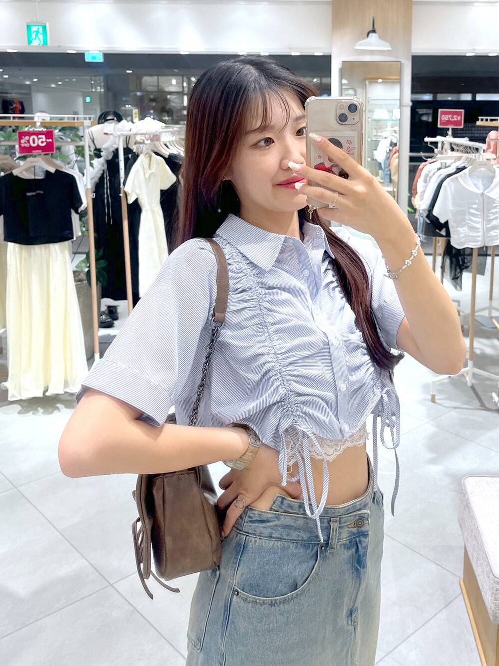 ブラウン系のショルダーバッグ、ホワイト系のキャミソール、ブラック系のサンダルを着用したレディースの夏コーディネートの2枚目の写真