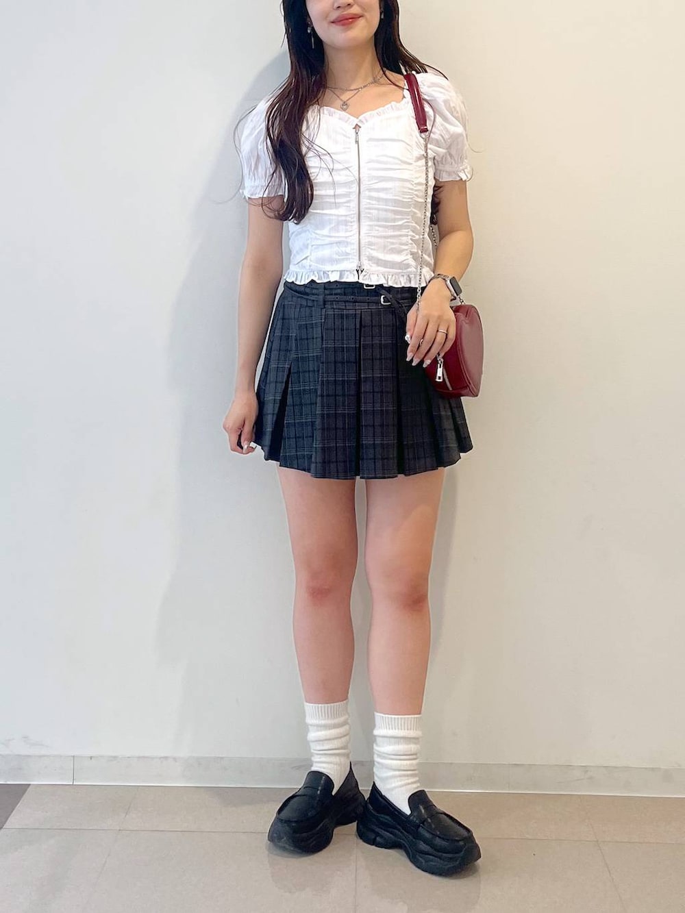 ホワイト系のキャミソール、ブラック系のローファー、グレー系のスカートを着用したレディースの春コーディネートの6枚目の写真