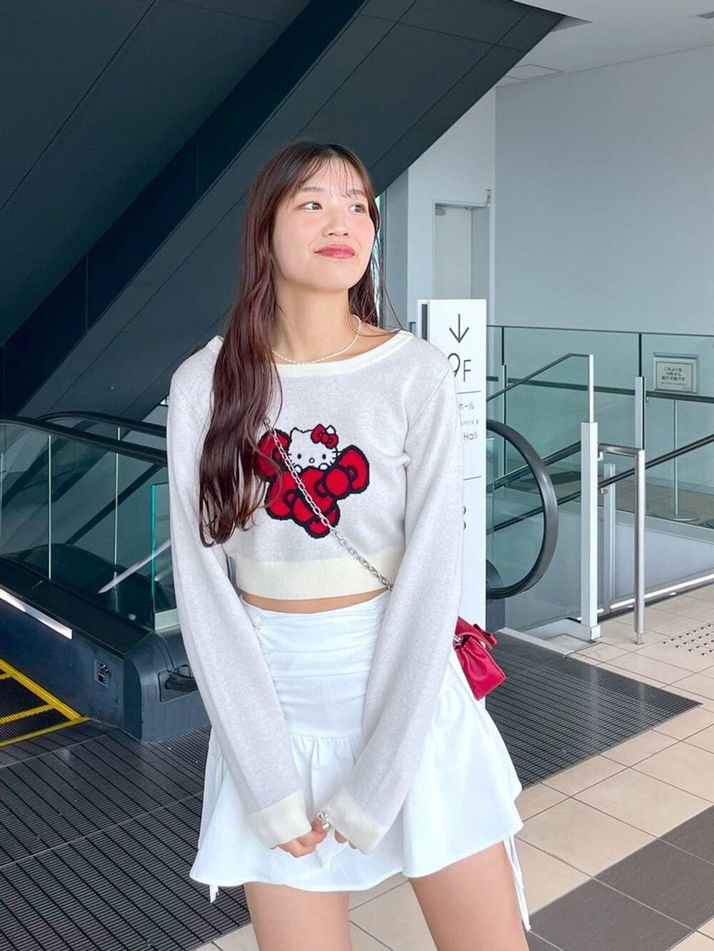 ホワイト系のTシャツ/カットソー、レッド系のショルダーバッグ、ブラック系のブーツを着用したレディースの秋コーディネートの7枚目の写真