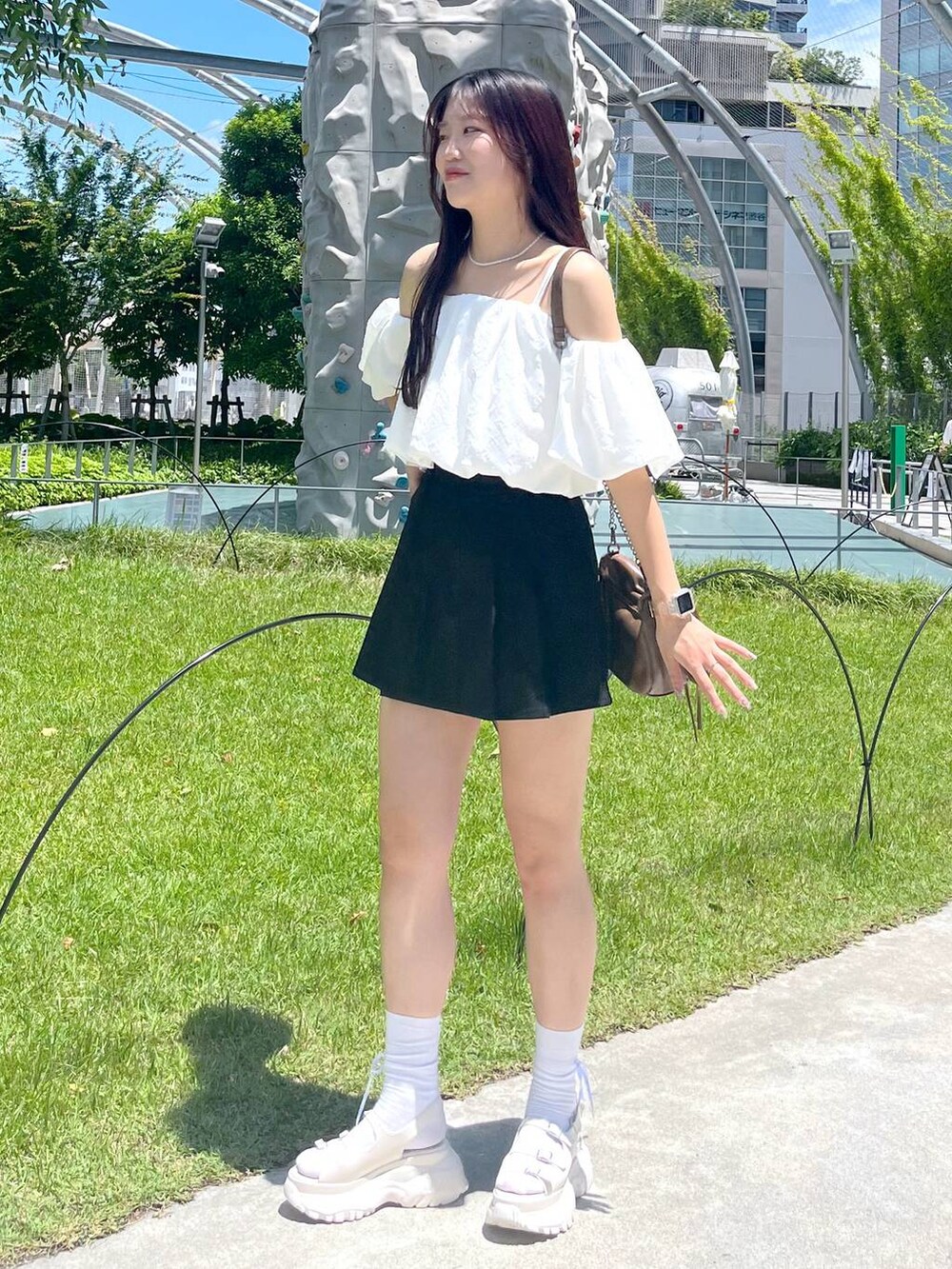 ブラック系のスカート、ホワイト系のシャツ/ブラウス、ホワイト系のキャミソールを着用したレディースの夏コーディネートの2枚目の写真