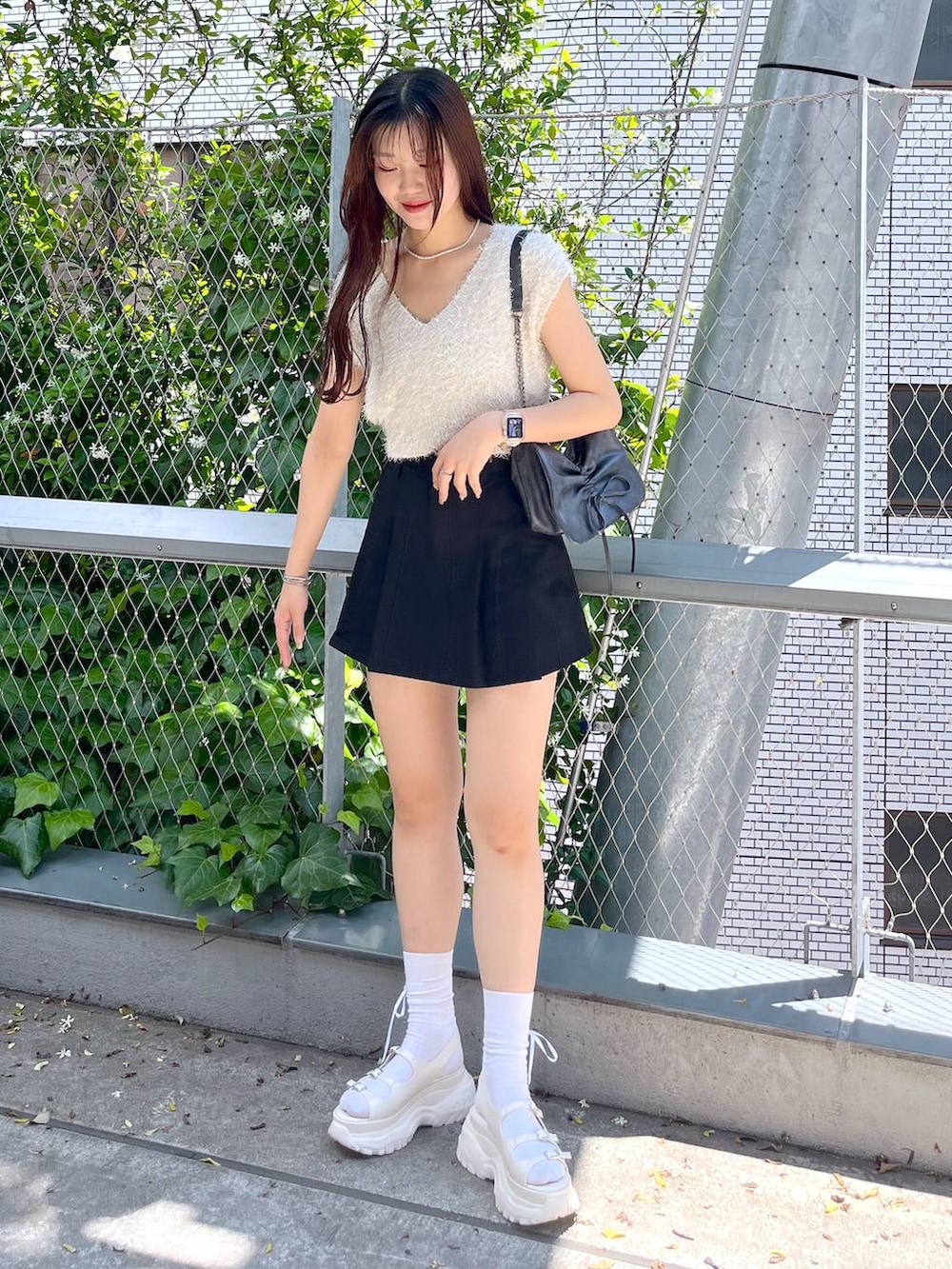 ブラック系のスカート、ホワイト系のキャミソール、ホワイト系のサンダルを着用したレディースの夏コーディネートの3枚目の写真