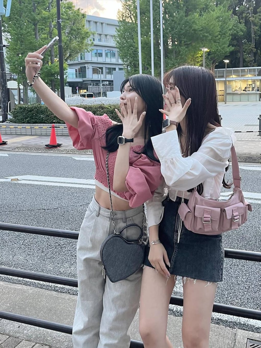 ピンク系のショルダーバッグ、ブラック系のショルダーバッグ、グレー系のデニムパンツを着用したレディースの春コーディネートの4枚目の写真