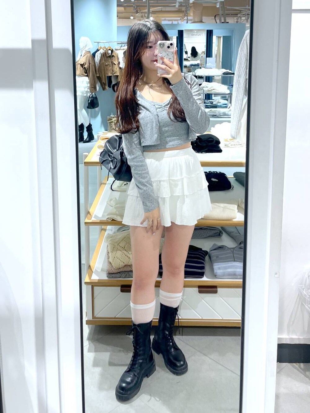 ブラウン系のショルダーバッグ、ホワイト系のキャミソール、ブラック系のブーツを着用したレディースの春コーディネートの5枚目の写真