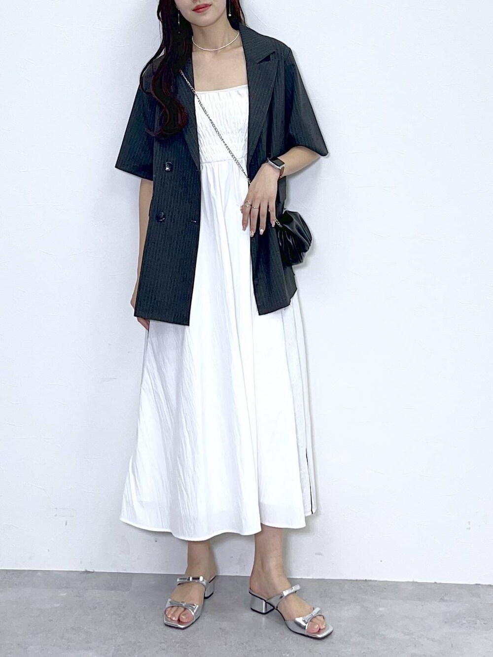 ブラック系のショルダーバッグ、シルバー系のサンダル、ホワイト系のワンピースを着用したレディースの夏コーディネートの5枚目の写真