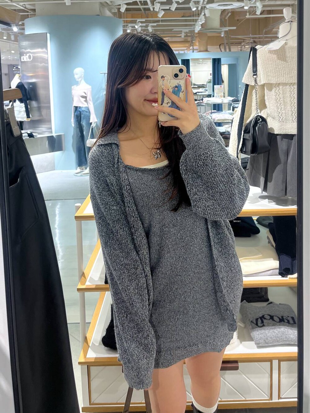 ブラウン系のショルダーバッグ、ブラック系のブーツ、ホワイト系のTシャツ/カットソーを着用したレディースの冬コーディネートの6枚目の写真