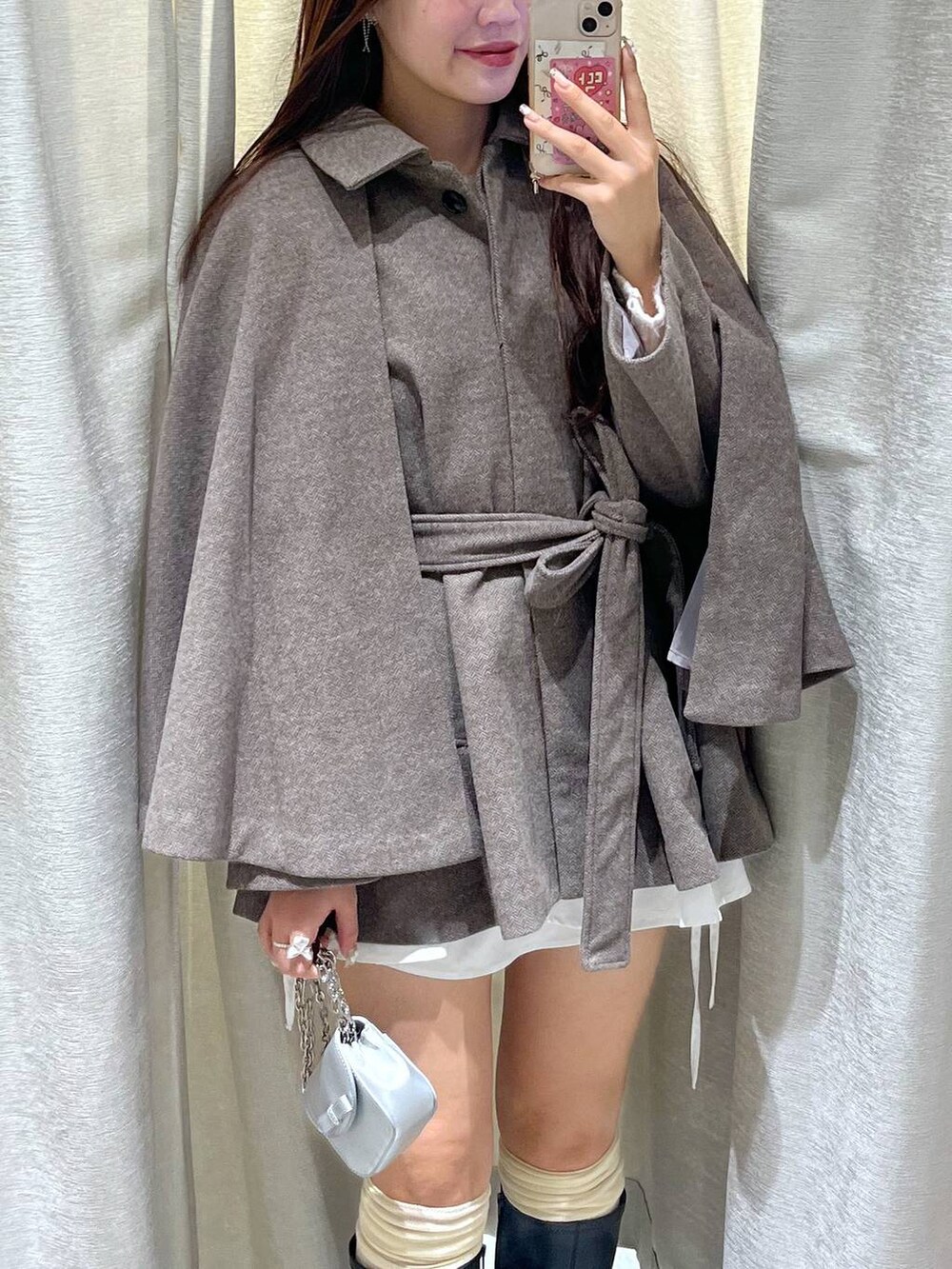 ブラウン系のステンカラーコート、ホワイト系のTシャツ/カットソー、ピンク系のカーディガン/ボレロを着用したレディースの秋コーディネートの7枚目の写真