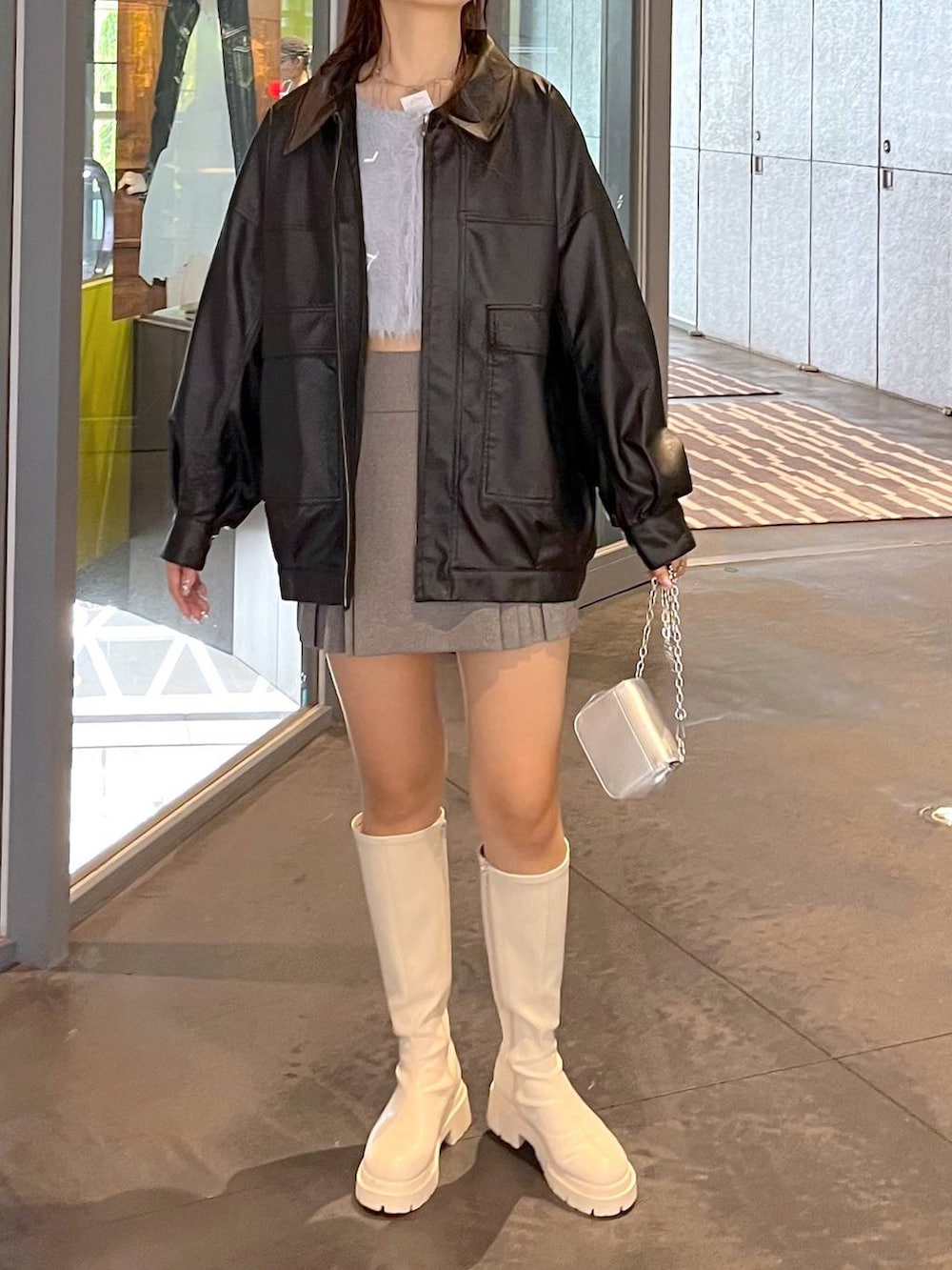 グレー系のスカート、ブルー系のカーディガン/ボレロ、ホワイト系のブーツを着用したレディースの秋コーディネートの4枚目の写真