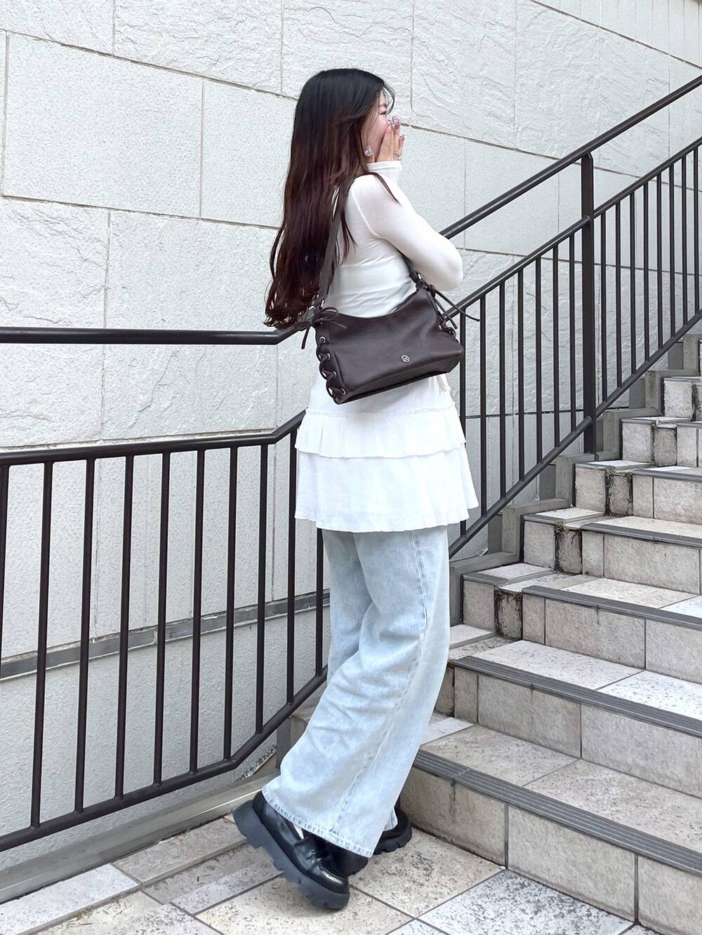 ホワイト系のキャミソール、ブルー系のデニムパンツ、ホワイト系のスカートを着用したレディースの春コーディネートの7枚目の写真