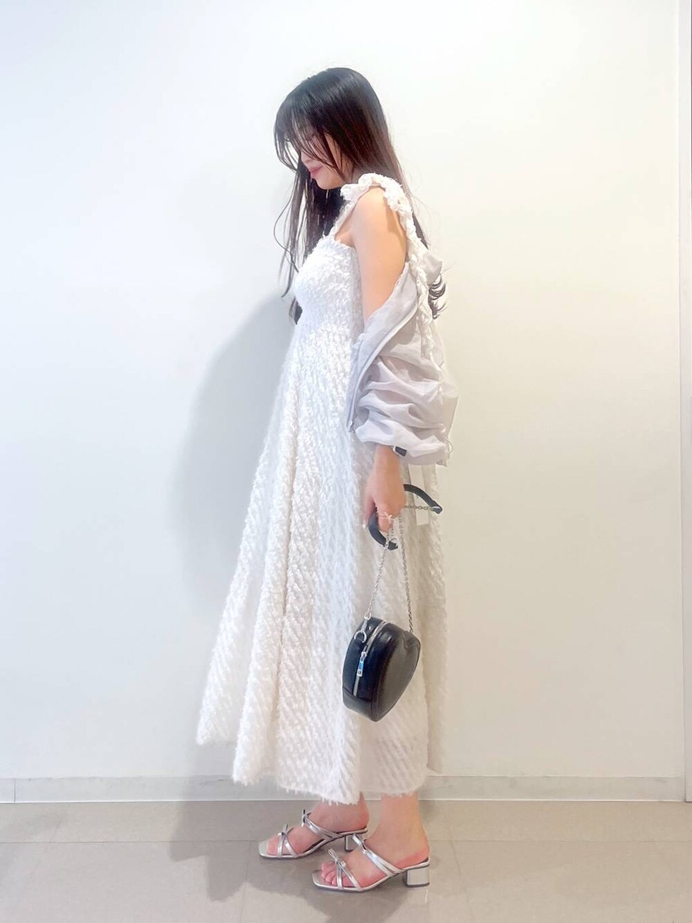 シルバー系のサンダル、ホワイト系のワンピース、グレー系のブルゾンを着用したレディースの春コーディネートの3枚目の写真