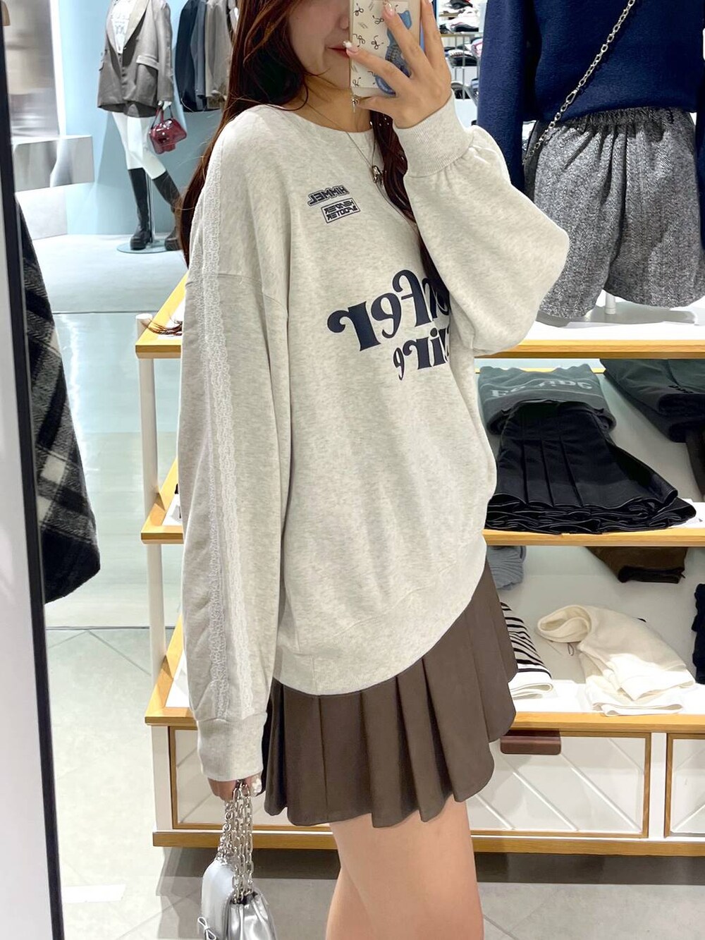 ホワイト系のTシャツ/カットソー、ブラウン系のスカート、ベージュ系のブーツを着用したレディースの秋コーディネートの3枚目の写真