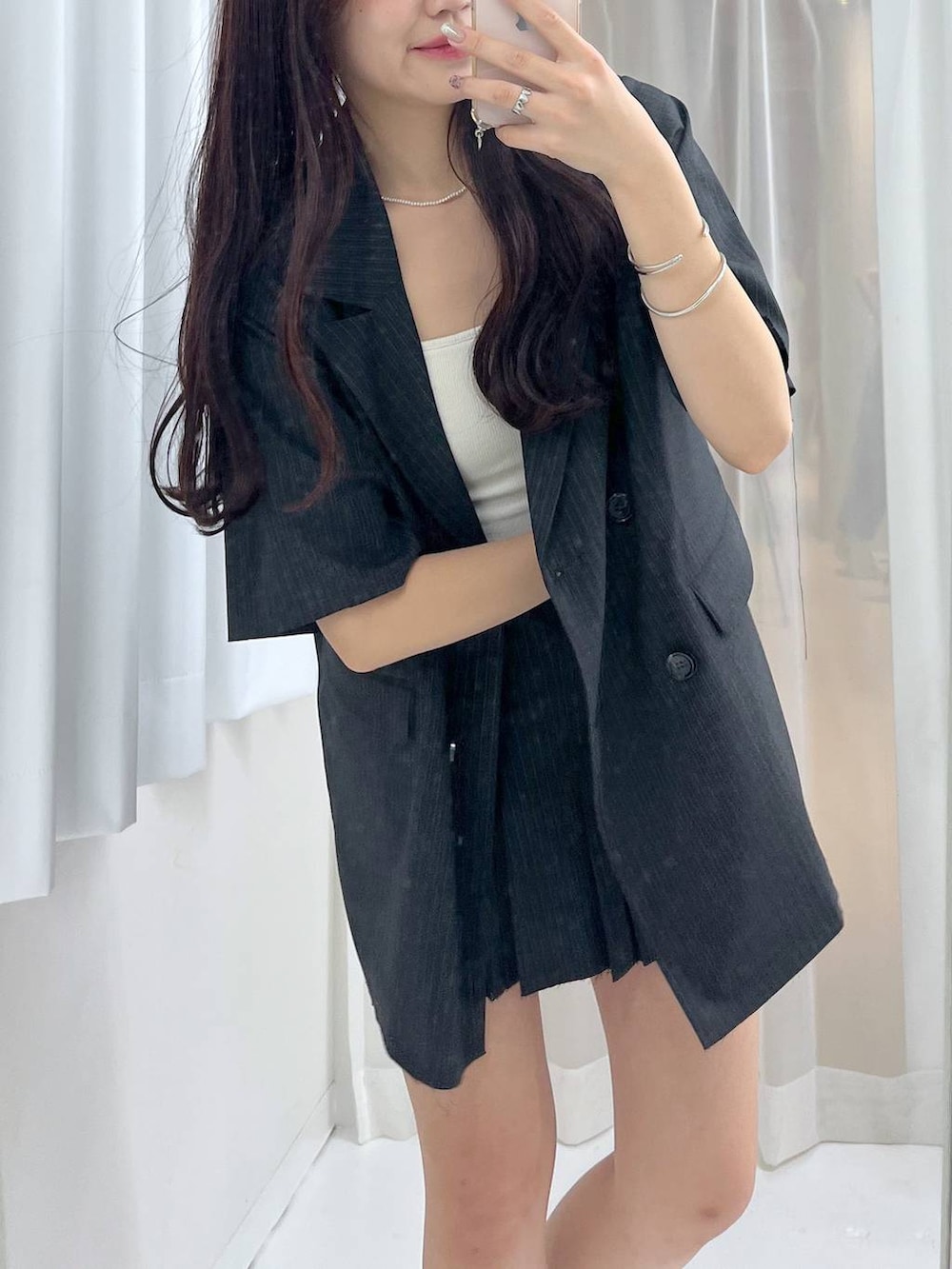 グレー系のスカート、ホワイト系のキャミソール、シルバー系のパンプスを着用したレディースの春コーディネートの3枚目の写真