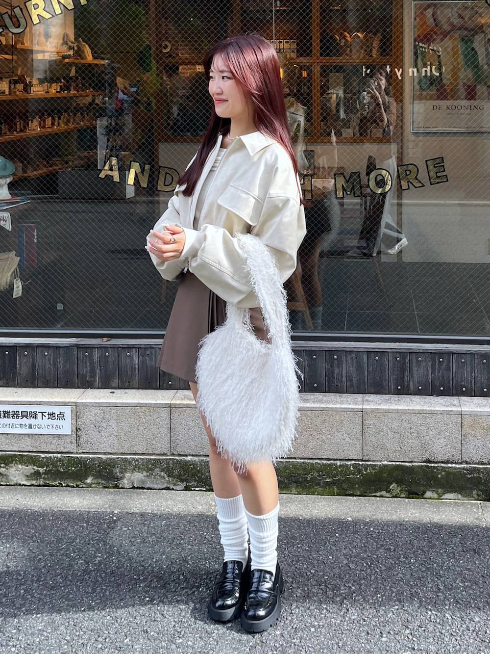 ブラウン系のスカート、ホワイト系のショルダーバッグ、ブラック系のローファーを着用したレディースの秋コーディネートの6枚目の写真