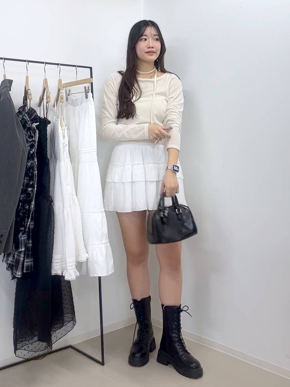 ホワイト系のキャミソール、ホワイト系のスカート、ブラック系のブーツを着用したレディースの春コーディネートの3枚目の写真