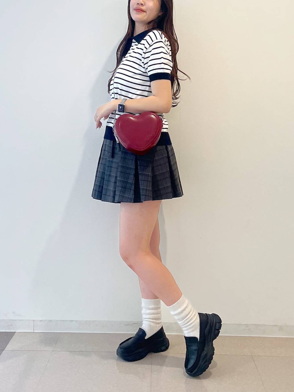 ホワイト系のキャミソール、ブラック系のローファー、グレー系のスカートを着用したレディースの春コーディネートの7枚目の写真