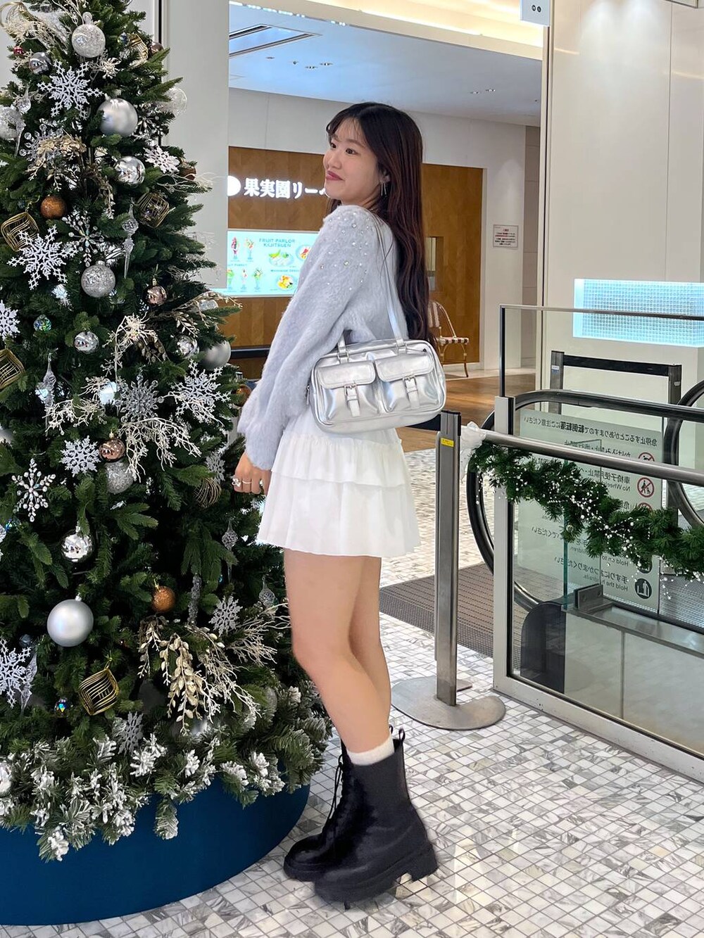 ホワイト系のTシャツ/カットソー、ブラック系のブーツ、シルバー系のショルダーバッグを着用したレディースの秋コーディネートの4枚目の写真