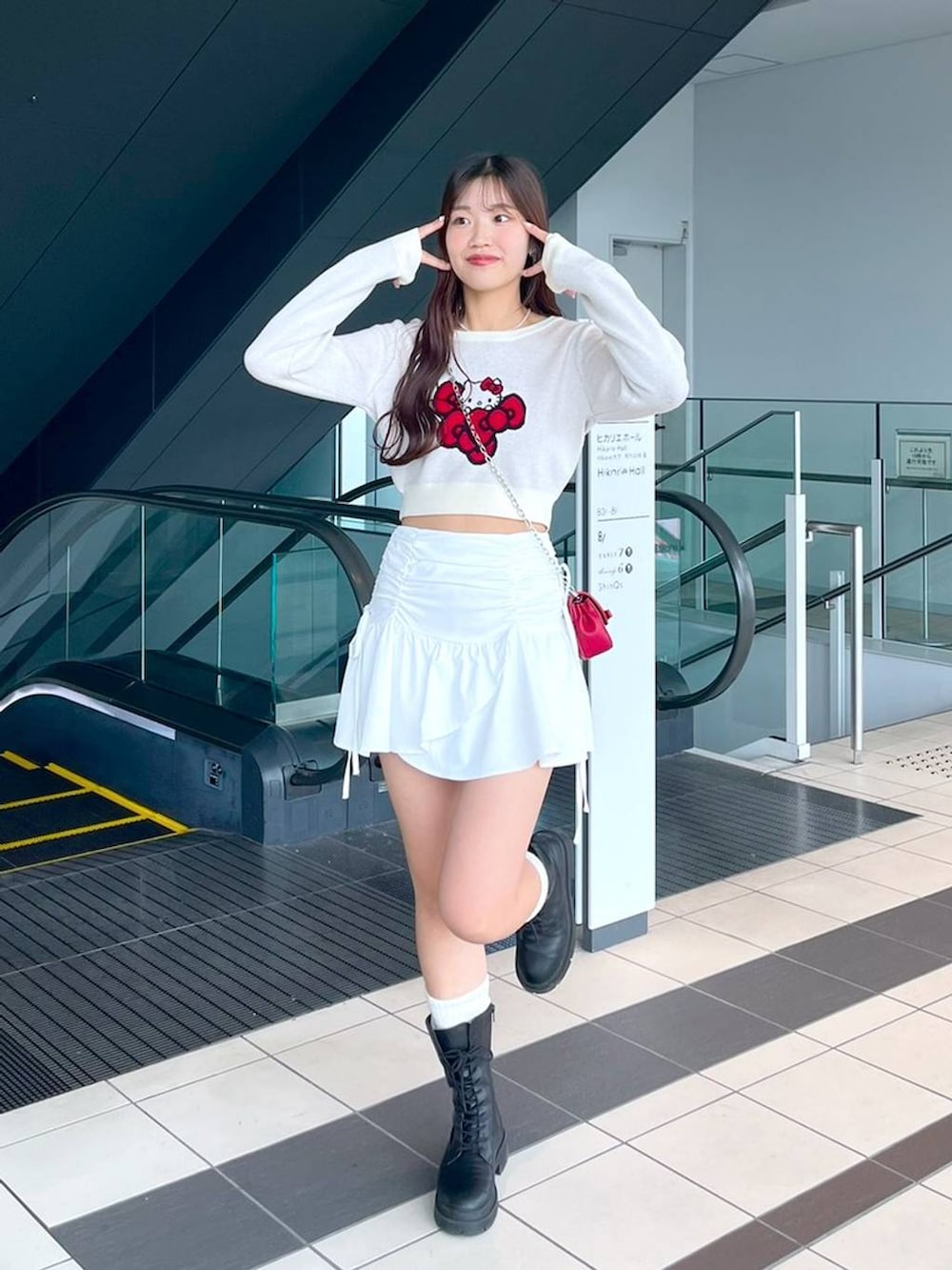 ホワイト系のTシャツ/カットソー、レッド系のショルダーバッグ、ブラック系のブーツを着用したレディースの秋コーディネートの4枚目の写真