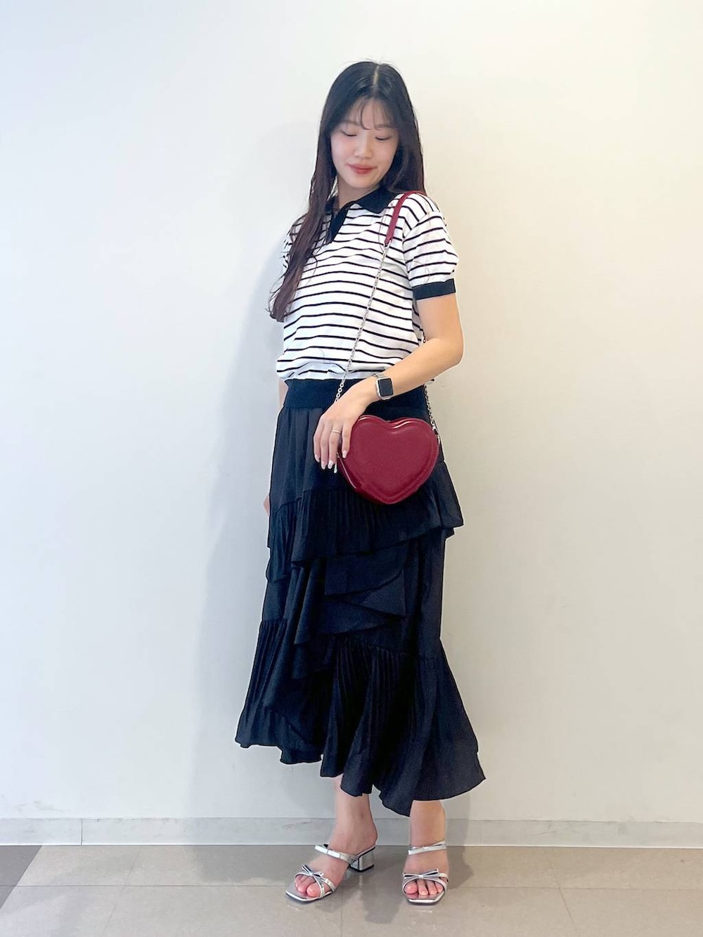 ホワイト系のキャミソール、ブラック系のスカート、シルバー系のサンダルを着用したレディースの春コーディネートの6枚目の写真