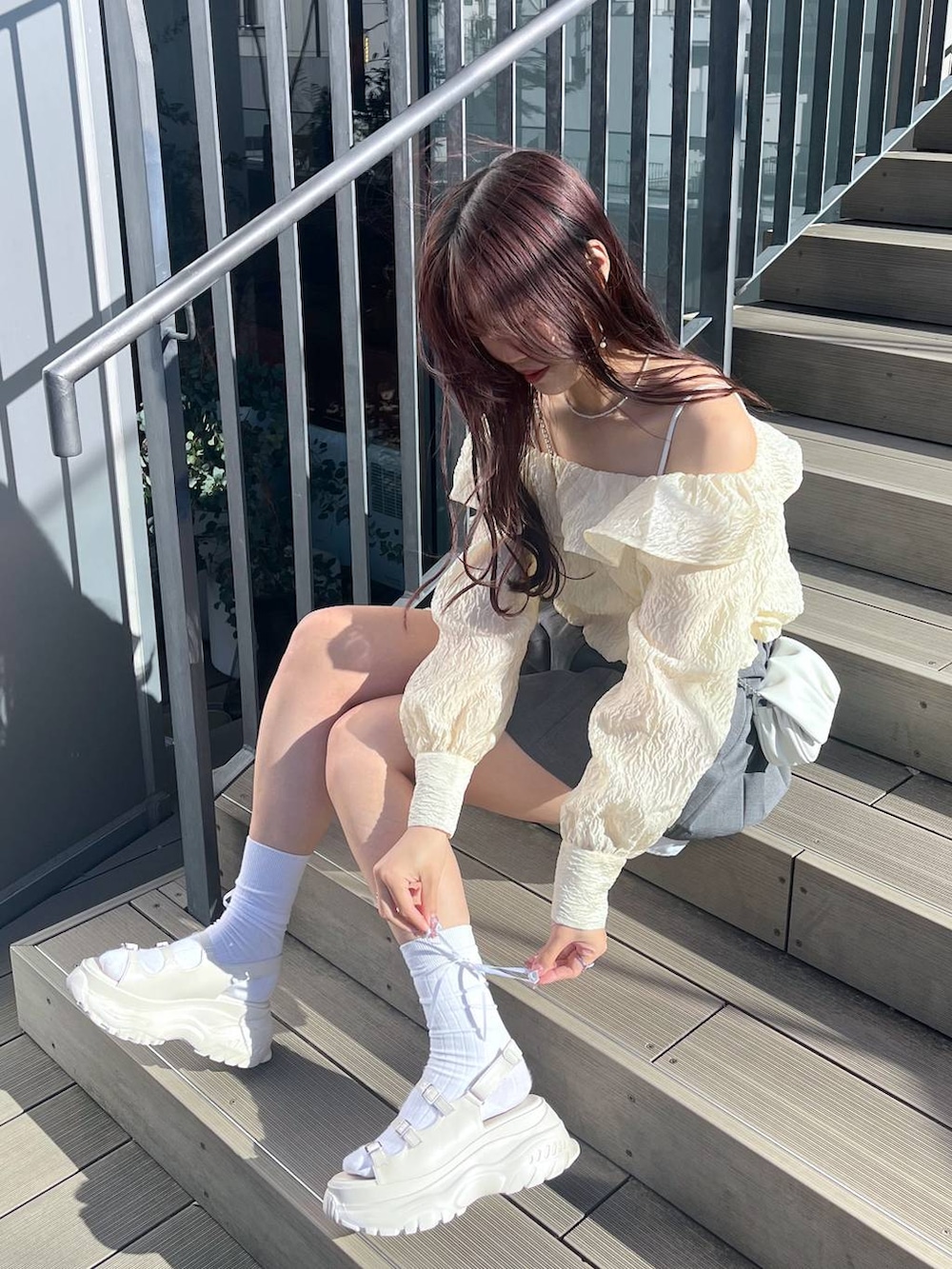 ホワイト系のショルダーバッグ、ホワイト系のキャミソール、ホワイト系のサンダルを着用したレディースの春コーディネートの2枚目の写真