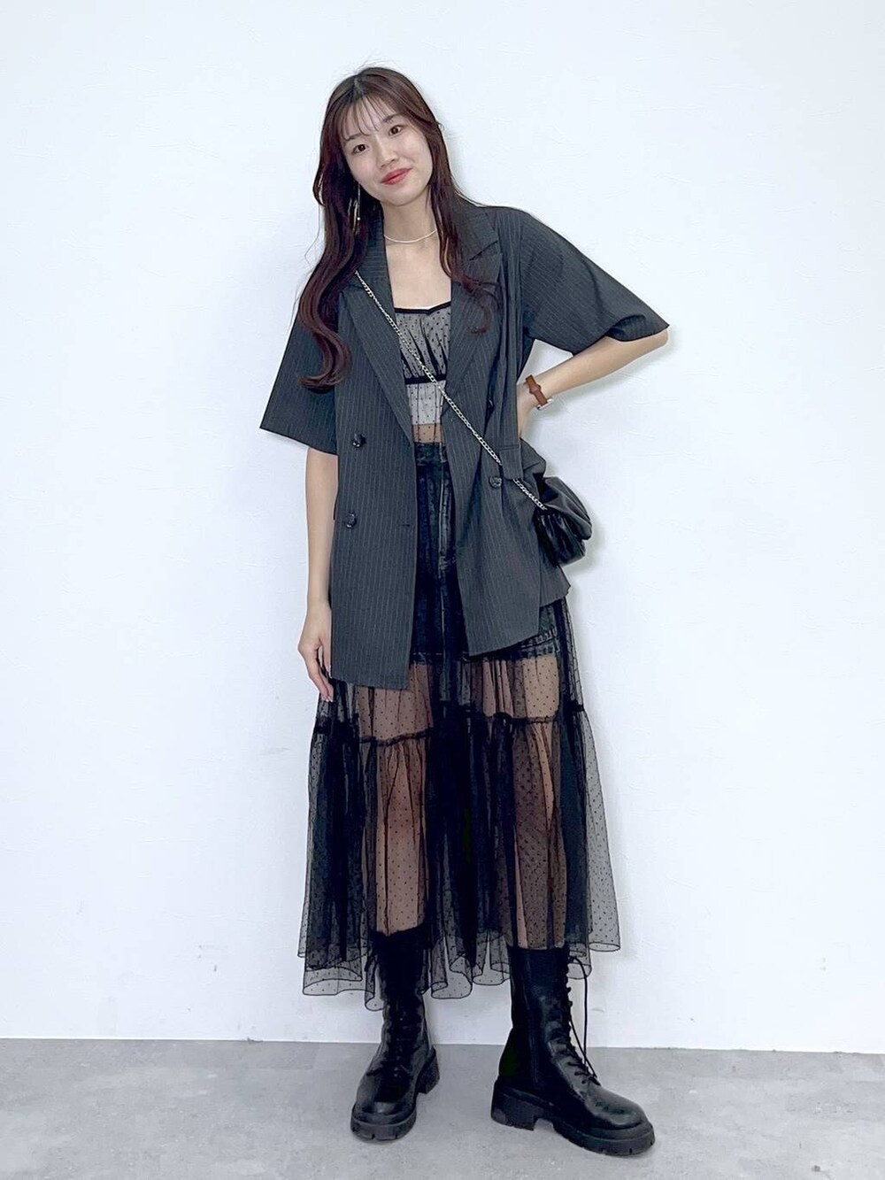 ブラック系のショルダーバッグ、ホワイト系のキャミソール、ブラック系のブーツを着用したレディースの夏コーディネートの6枚目の写真