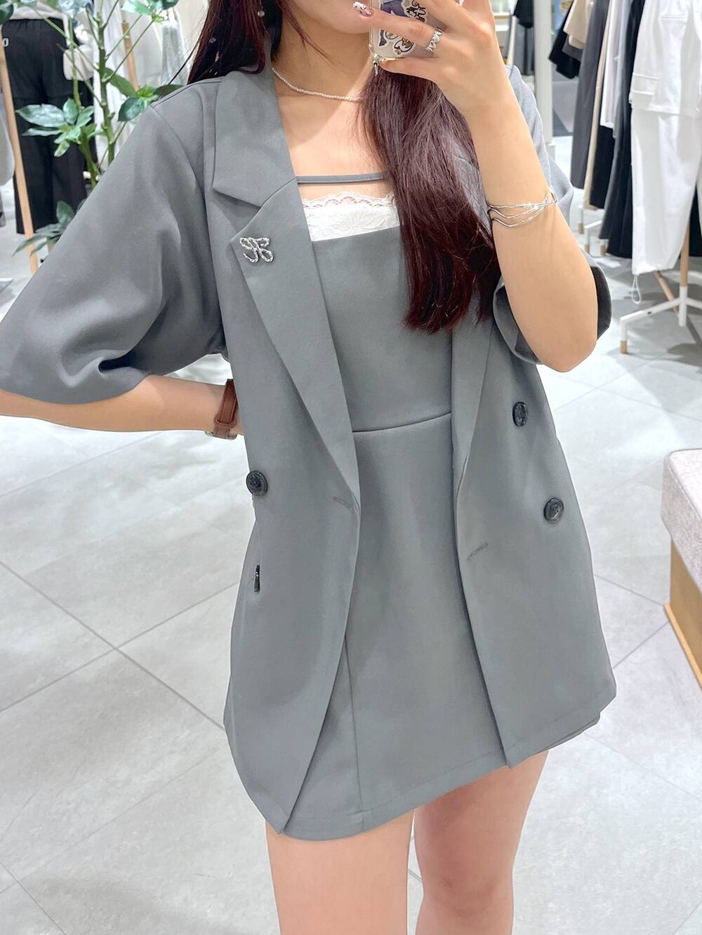 グレー系のワンピース、ブラック系のローファー、ホワイト系のキャミソールを着用したレディースの春コーディネートの4枚目の写真