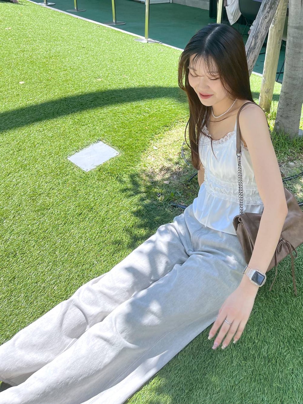 ホワイト系のキャミソール、グレー系のデニムパンツ、ホワイト系のサンダルを着用したレディースの夏コーディネートの8枚目の写真