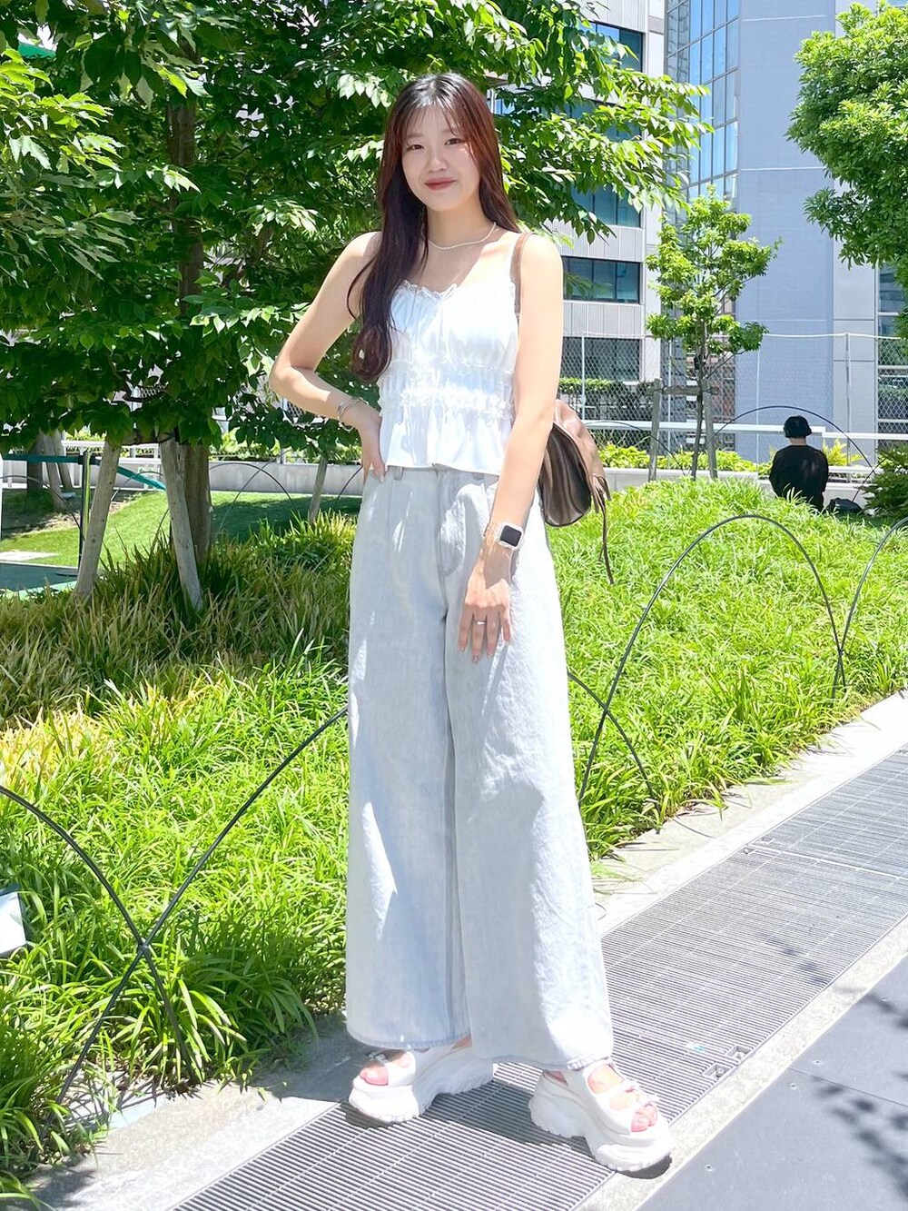 ホワイト系のキャミソール、グレー系のデニムパンツ、ホワイト系のサンダルを着用したレディースの夏コーディネートの3枚目の写真