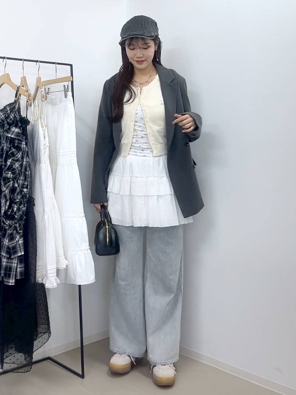 ホワイト系のキャミソール、ブルー系のデニムパンツ、ホワイト系のスカートを着用したレディースの春コーディネートの2枚目の写真