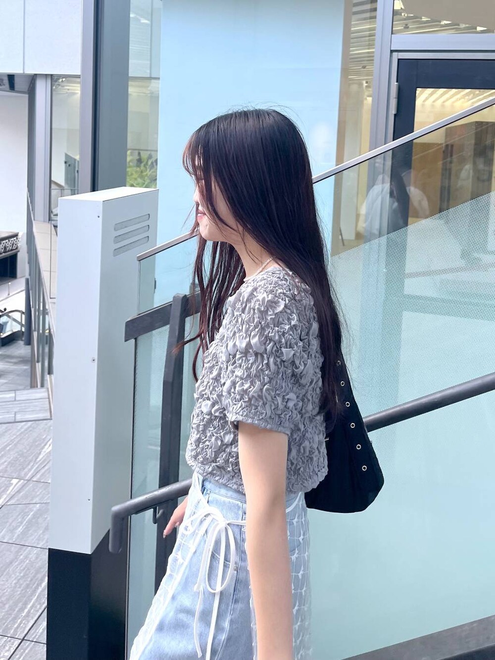 シルバー系のサンダル、ホワイト系のキャミソール、ブルー系のデニムパンツを着用したレディースの夏コーディネートの7枚目の写真