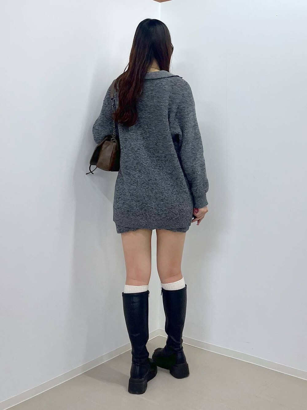 ブラウン系のショルダーバッグ、ホワイト系のキャミソール、ブラック系のブーツを着用したレディースの春コーディネートの6枚目の写真