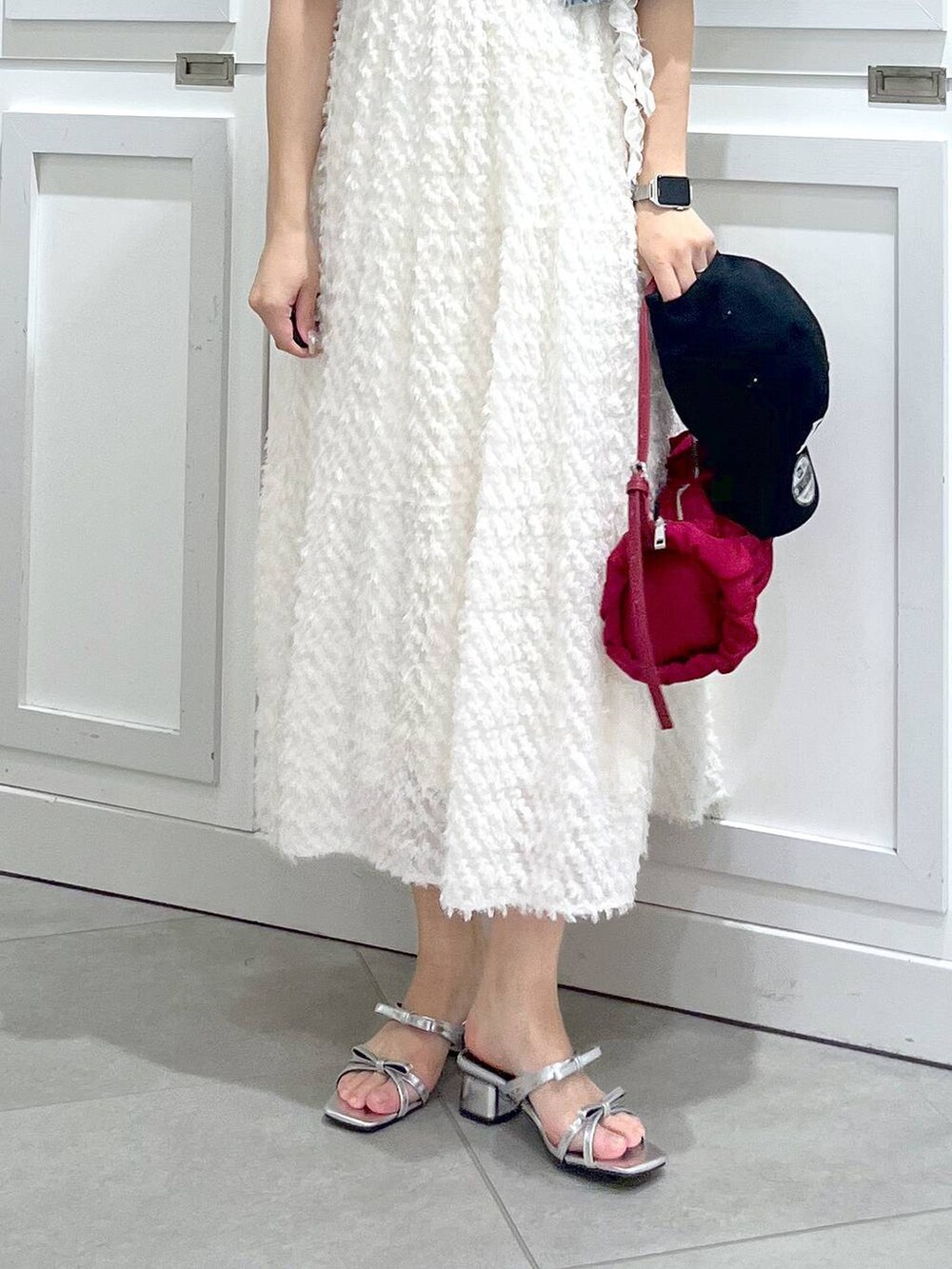 シルバー系のサンダル、ブルー系のデニムジャケット、ホワイト系のワンピースを着用したレディースの春コーディネートの8枚目の写真