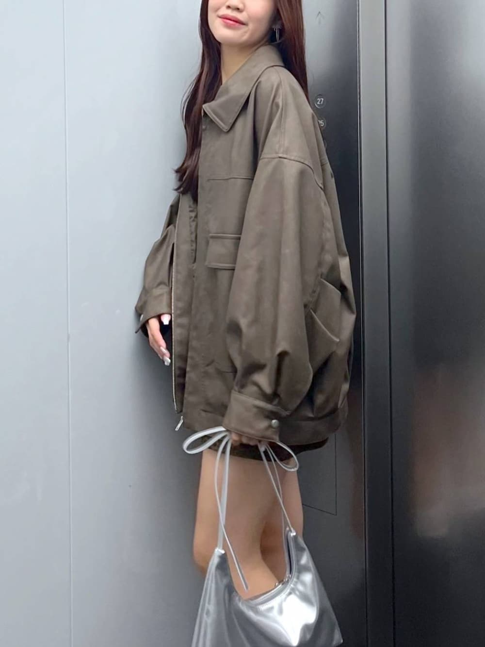 ブラウン系のブーツ、その他のスカート、シルバー系のショルダーバッグを着用したレディースの秋コーディネートの6枚目の写真