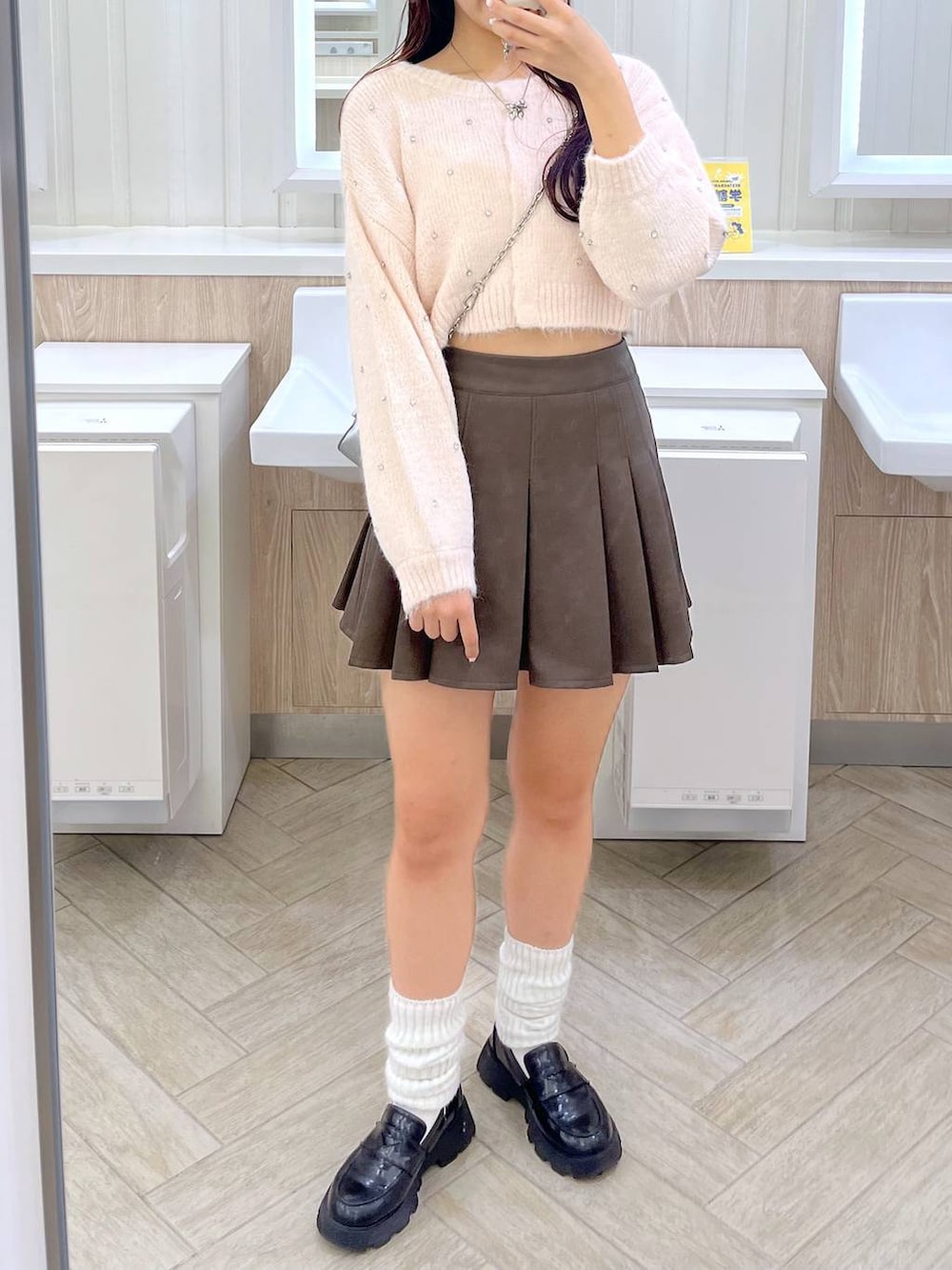 ピンク系のカーディガン/ボレロ、ホワイト系のキャミソール、ブラウン系のスカートを着用したレディースの秋コーディネートの3枚目の写真
