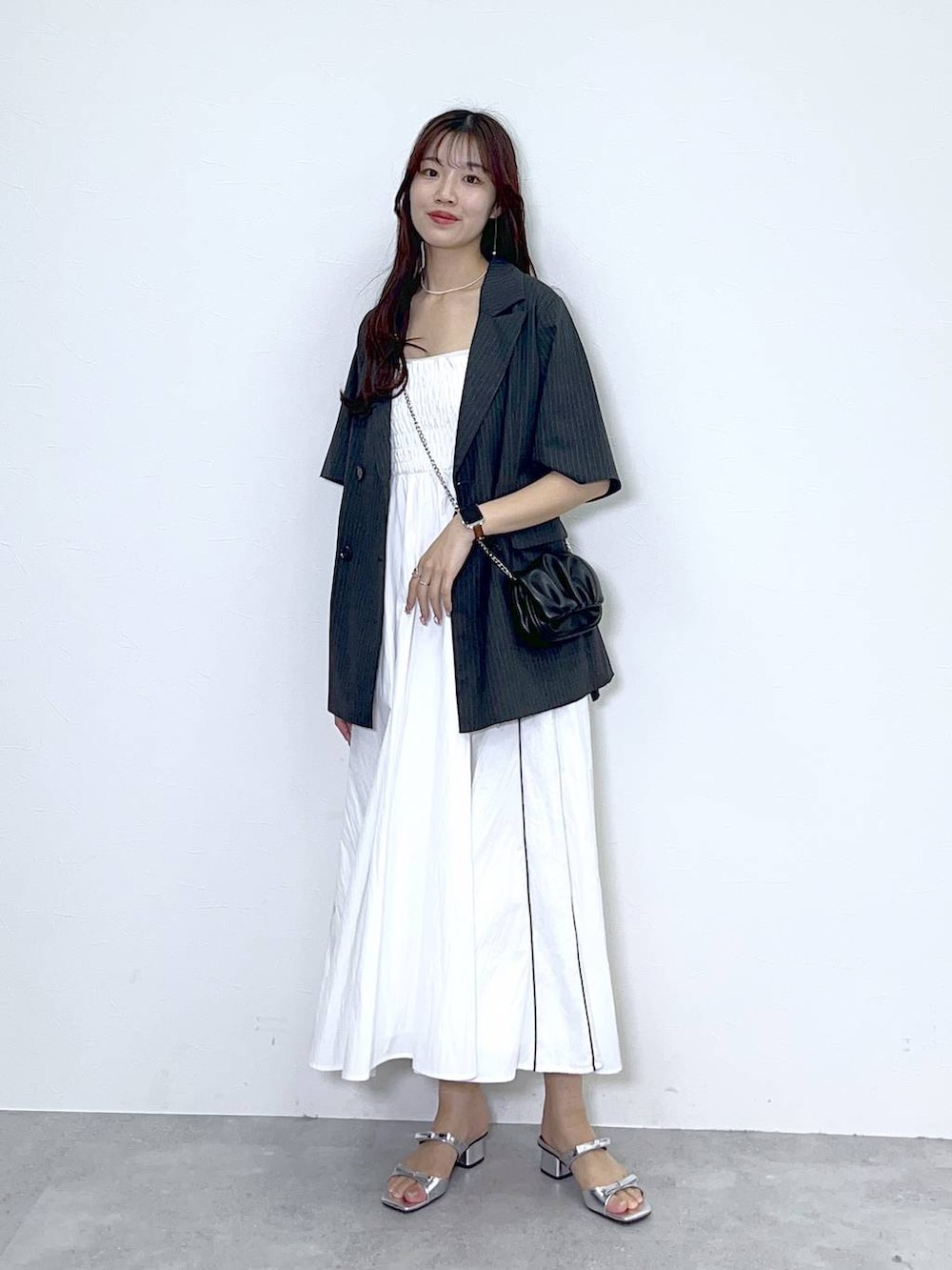 ブラック系のショルダーバッグ、シルバー系のサンダル、ホワイト系のワンピースを着用したレディースの春コーディネートの5枚目の写真
