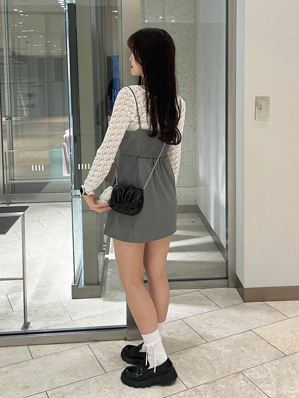 グレー系のワンピース、ホワイト系のキャミソール、ブラック系のローファーを着用したレディースの春コーディネートの4枚目の写真